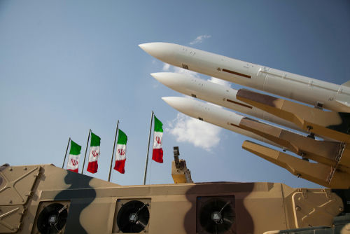 shutterstock1621002841-2jpg-1 Missiles on launchers beside Iranian flags.
