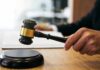 Clean Air Act Rewritten—Or Not? Judge's hand holding a gavel over a sound block