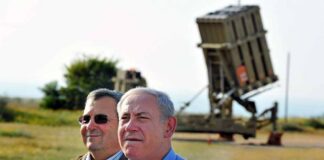 two men standing near a missile defense launcher outdoors