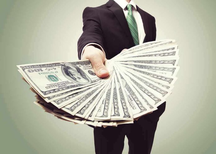 Businessperson holding a fan of US dollar bills