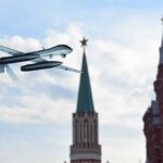 military drone flying near ornate red-brick towers