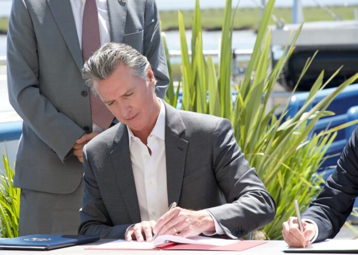 Larkspur,,Ca,-,April,16,,2024:,Governor,Gavin,Newsom,And Aerial view of a coastal cliff with a small structure.
