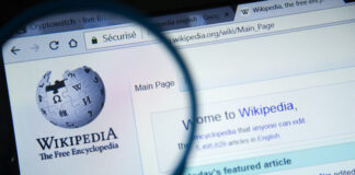 Wikipedia homepage viewed through a magnifying glass.